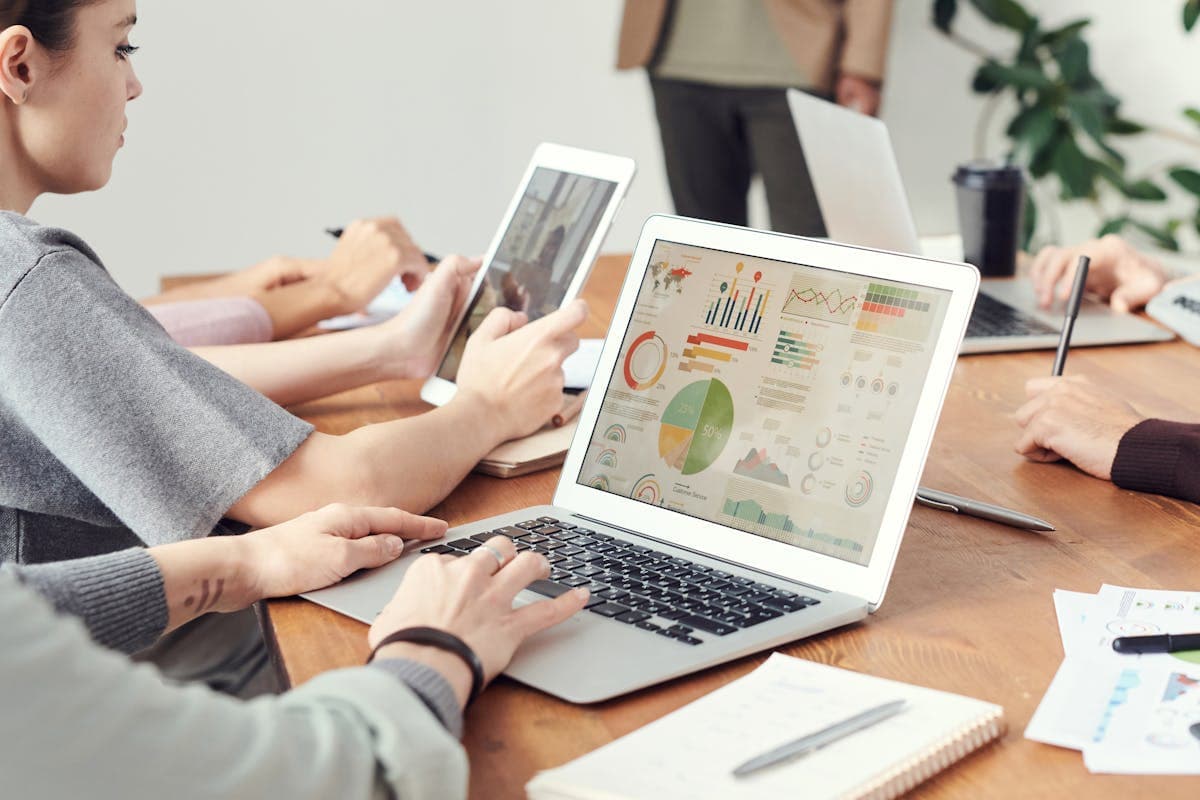 Team analyzing data on laptops during a meeting to evaluate AI browser agents